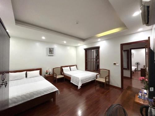 a hotel room with two beds and a mirror at Sam Son Golden Dream Hotel in Sầm Sơn