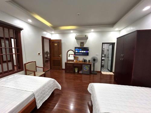 a bedroom with two beds and a television in it at Sam Son Golden Dream Hotel in Sầm Sơn
