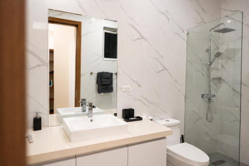 a white bathroom with a sink and a shower at The Nook in Kingston