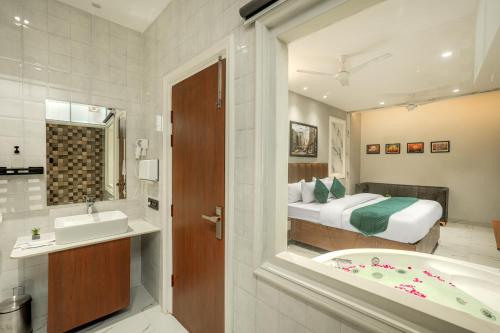 a bathroom with a bed and a tub and a sink at The Leaf in Ludhiana