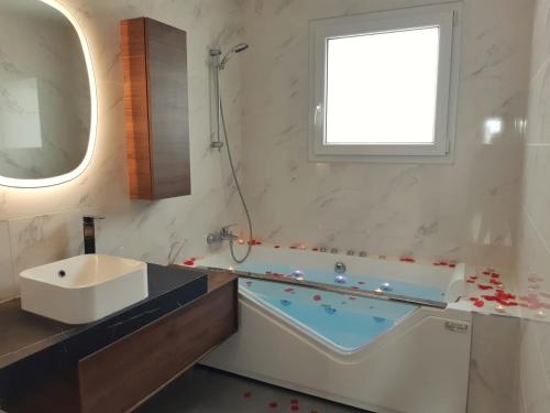 a bathroom with a bath tub and a sink at Bat'Appart -DIJON- Balnéo-insolite-parking gratuit in Longvic
