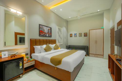 a bedroom with a large bed and a television at The Leaf in Ludhiana