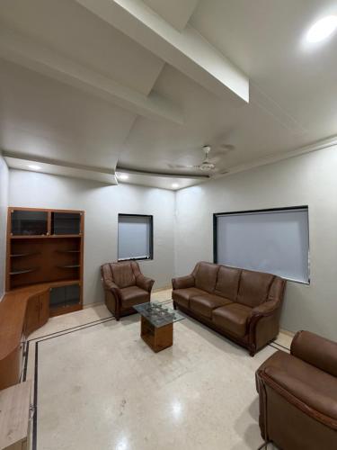 a living room with two couches and a screen at The Highstreet Stay in Pune