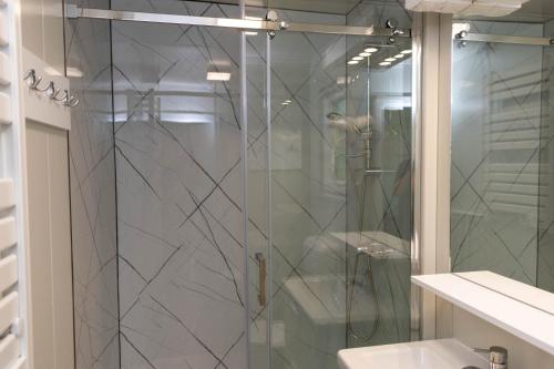 a shower with a glass door in a bathroom at Igal Thermal Camping in Igal