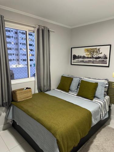 a bedroom with a large bed with a window at ACONCHEGO E BEM ESTAR in Brasília