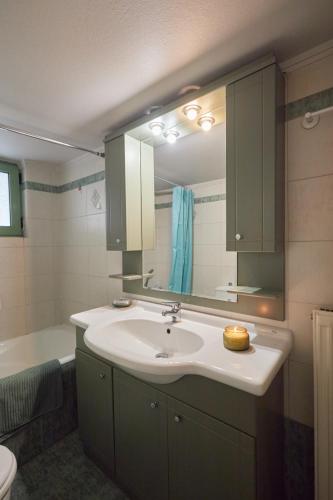 a bathroom with a sink and a large mirror at Moschato-Niarchos modern apartment in Piraeus