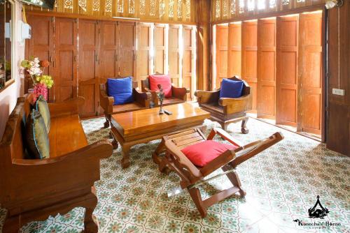 a living room with couches and a table and chairs at Kanecha's Home Lampang in Lampang