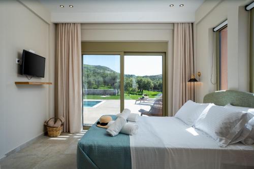 a bedroom with a bed and a sliding glass door at Vedema Homes in Lefkogeia