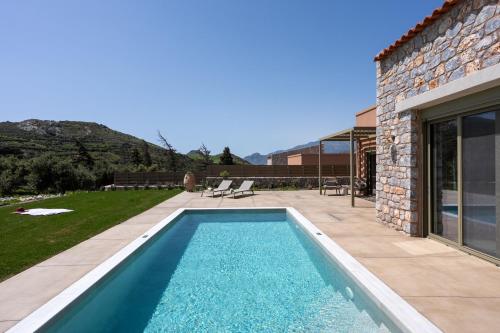 a swimming pool in the backyard of a house at Vedema Homes in Lefkogeia