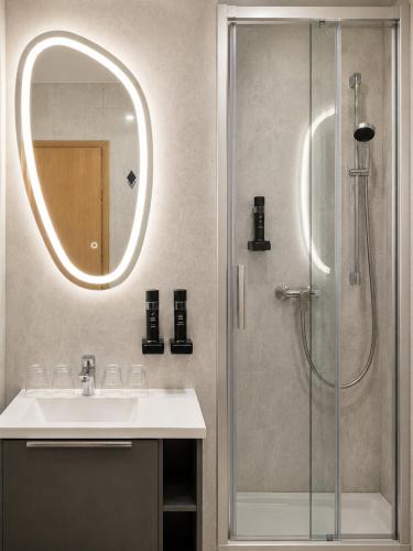 a bathroom with a sink and a shower with a mirror at Pension am Markt in Wurzen