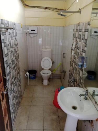 a bathroom with a toilet and a sink at countryside view hotel Silchar in Silchar