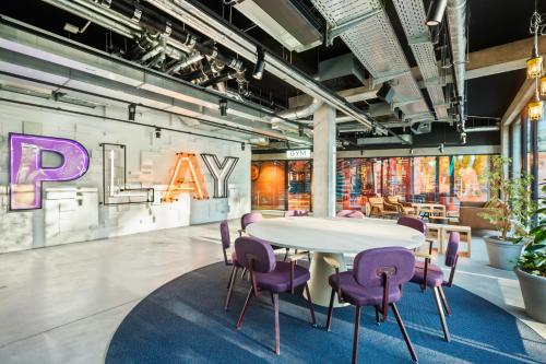 a conference room with a table and purple chairs at The Social Hub Berlin Alexanderplatz in Berlin