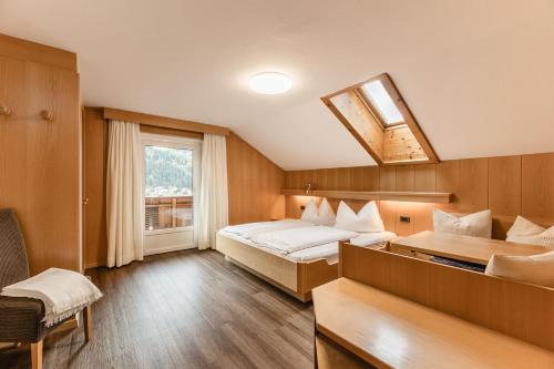 a hotel room with two beds and a window at Apartments Chalet Zirm in Santa Cristina Gherdëina
