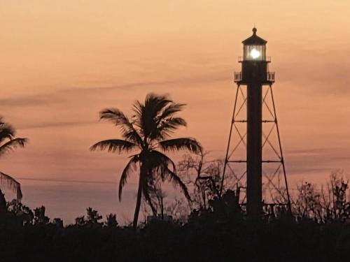a lighthouse with a clock tower with a palm tree at Lighthouse Point A311 in Sanibel
