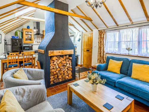 a living room with a blue couch and a fireplace at Corner Cottage in Saxmundham