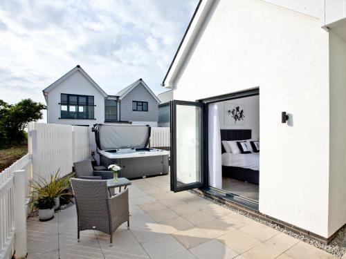 a white house with a patio with a bed at Black Sea Horse in Westward Ho