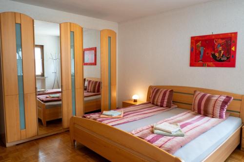 a small bedroom with a bed and a mirror at Ferienwohnung Riesling in Klüsserath