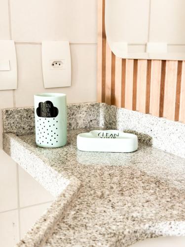 a bathroom counter top with a white soap dispenser on it at Vg Sun Cumbuco 112 in Caucaia