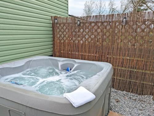 a hot tub sitting next to a fence at Solo's in East Heslerton