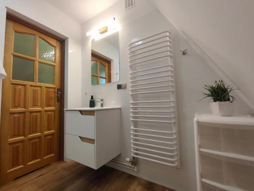 a bathroom with a staircase with a sink and a mirror at Leśny Poranek in Iwkowa