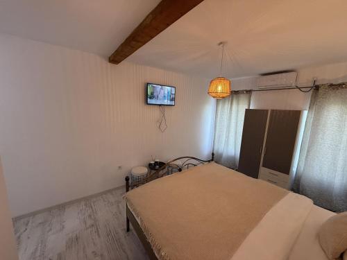 a bedroom with a bed and a tv on the wall at Cazare Vidin in Basarabi