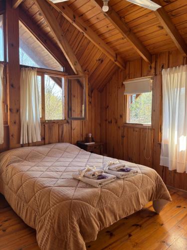 a bedroom with a bed in a wooden cabin at La Secreta in Villa Giardino