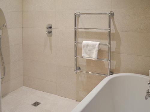 a bathroom with a shower with a tub and a towel rack at Midge in Newlyn