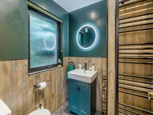 a bathroom with a blue sink and a mirror at Lochside View in Lochearnhead