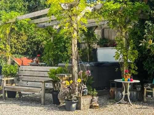 a garden with a bench and a table with flowers at Rosehill in Truro