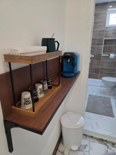a bathroom with a shelf with cups and a toilet at The Cosy House in Kyustendil