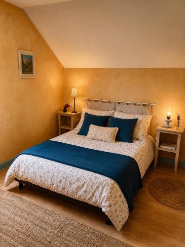 a bedroom with a large bed with blue sheets at Ecurie Piaffe & Cie in Lurais
