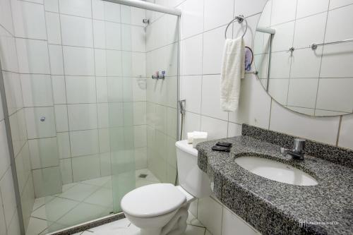 a bathroom with a toilet and a sink and a shower at Rede Andrade Royal in Itabuna