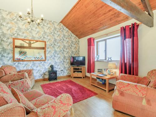 a living room with a couch and a tv at The Cartlinhay - Uk35756 in Bideford