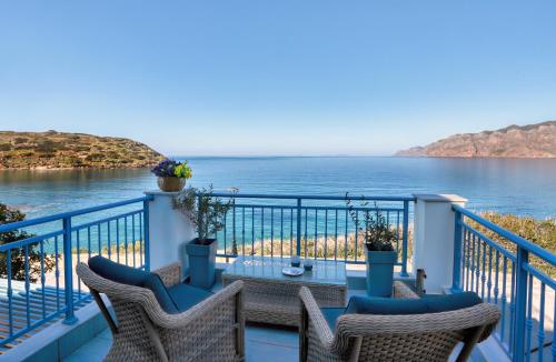 a balcony with chairs and a table and the ocean at Seafront Villa Moments, by Estia in Mochlos