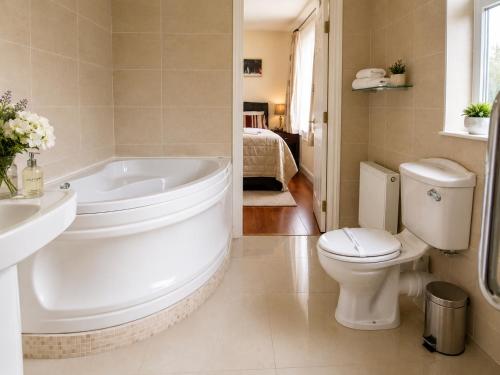 ein Badezimmer mit Badewanne, Toilette und Waschbecken in der Unterkunft Edencrest B&B in Bantry