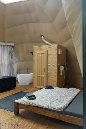 a room with a bed and a tub in a tent at Glamping Prague Louka in Prague