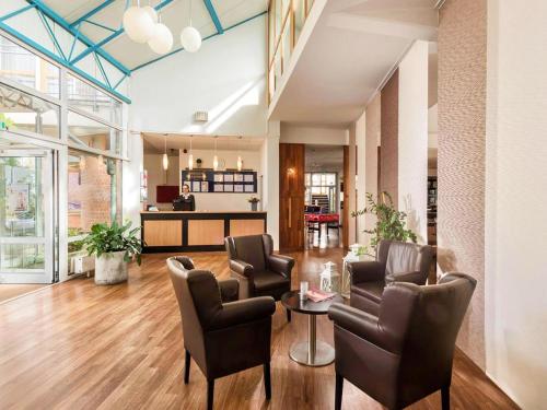 a lobby with chairs and a table in a building at Braunschweig Seminarius Hotel by Belvilla in Braunschweig
