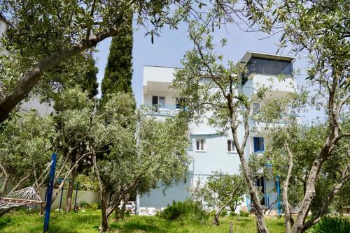 an apartment building seen through trees at Domizil Lina Art in Güzelçamlı