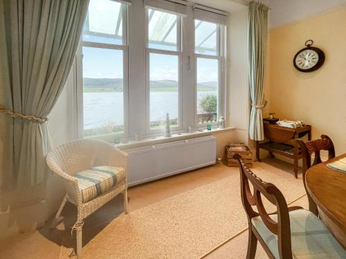 a living room with a large window and a table and chairs at Failte in Colintraive