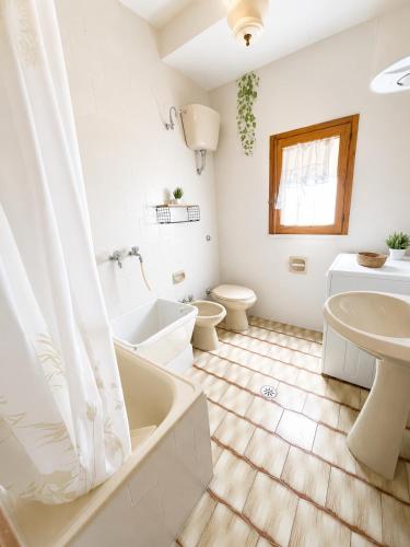 a bathroom with a tub and a toilet and a sink at Terrazza sul Borgo in Camerota