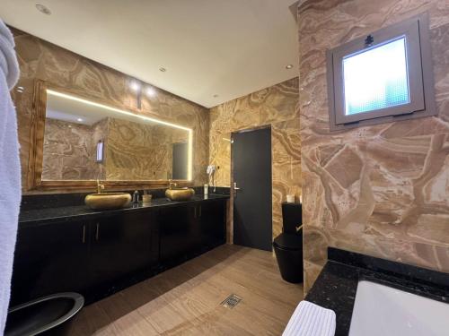 a bathroom with a sink and a television on the wall at RS Hôtel Karam Resort in Ouarzazate