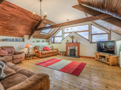 a living room with couches and a tv and a fireplace at The Threshing Barn - Uk35754 in Bideford