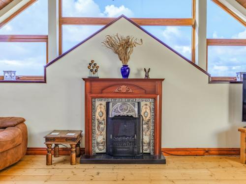 a living room with a fireplace in a house at The Threshing Barn - Uk35754 in Bideford