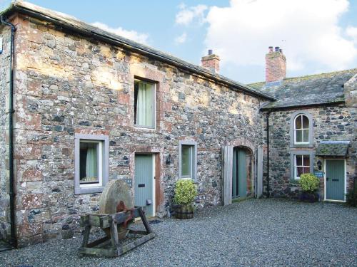 a stone building with a bench in front of it at The Old Stables in Uldale
