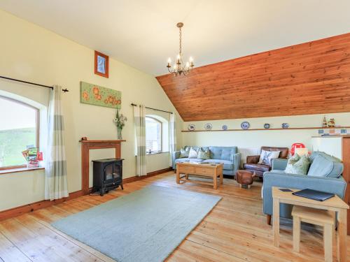 a living room with a blue couch and a fireplace at The Granary - Uk35755 in Bideford