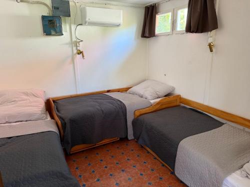 a group of three beds in a room at Duna Liget in Dunaföldvár