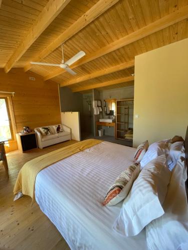 a large bed in a room with a wooden ceiling at Cabanas de Melides in Melides