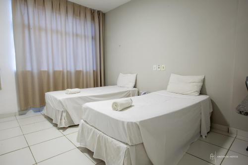 a room with two beds with towels on them at Rede Andrade Royal in Itabuna