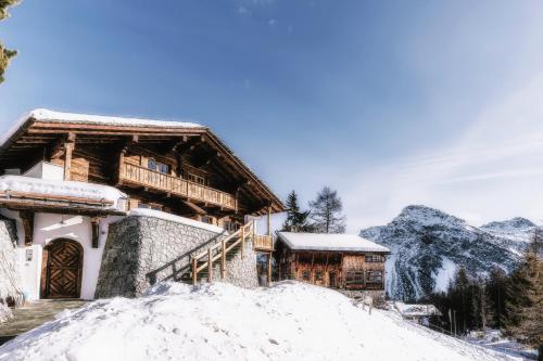 a log cabin in the mountains in the snow at Alpslodge - Amelia in Arosa