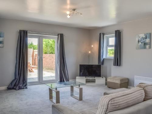 a living room with a couch and a tv at Dotterel Cottage - Uk39264 in Reighton